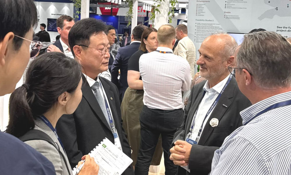Photo of ERTICO and DfT officials discussing developments with other delegates 